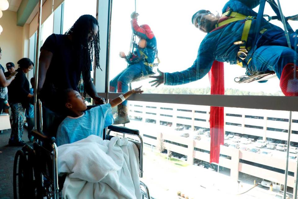 Kyler Spears, 5, and her father, Brandon, say hello to Superman, played by Miguel Aguilar, at WakeMed Children’s Hospital in Raleigh, N.C., Friday, October 4, 2019. The photo took first place for feature photography among the state’s largest newspapers in the North Carolina Press Association’s annual awards.