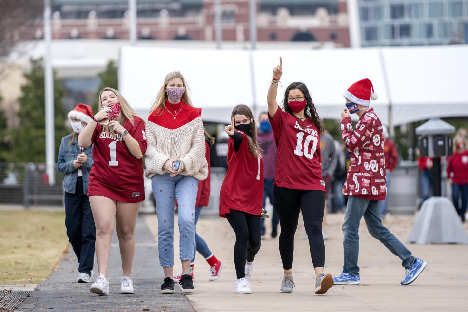 Oklahoma fans walk towards AT&T Stadium before an NCAA college football game against Iowa State for the Big 12 Conference championship, Saturday, Dec. 19, 2020, in Arlington, Texas. (AP Photo/Jeffrey McWhorter)