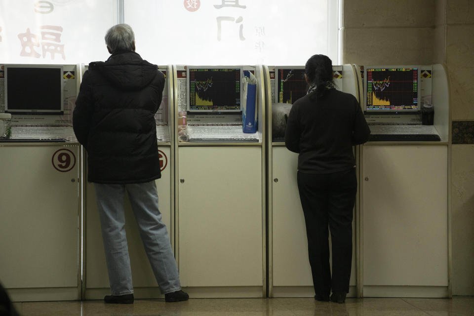 In this Thursday, Dec. 12, 2019, photo, investors monitor stock prices at a brokerage in Beijing. Shares likewise jumped Friday, Dec. 13, 2019 in Asia following fresh all-time highs overnight on Wall Street spurred by optimism that the U.S. and China are close to reaching a deal to end their costly trade war. (AP Photo/Ng Han Guan)