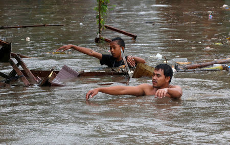 Residents wade in floodwaters in Bacoor, Cavite as a storm sweeps across the main Luzon island, Philippines, September 12, 2017. REUTERS/Erik De Castro