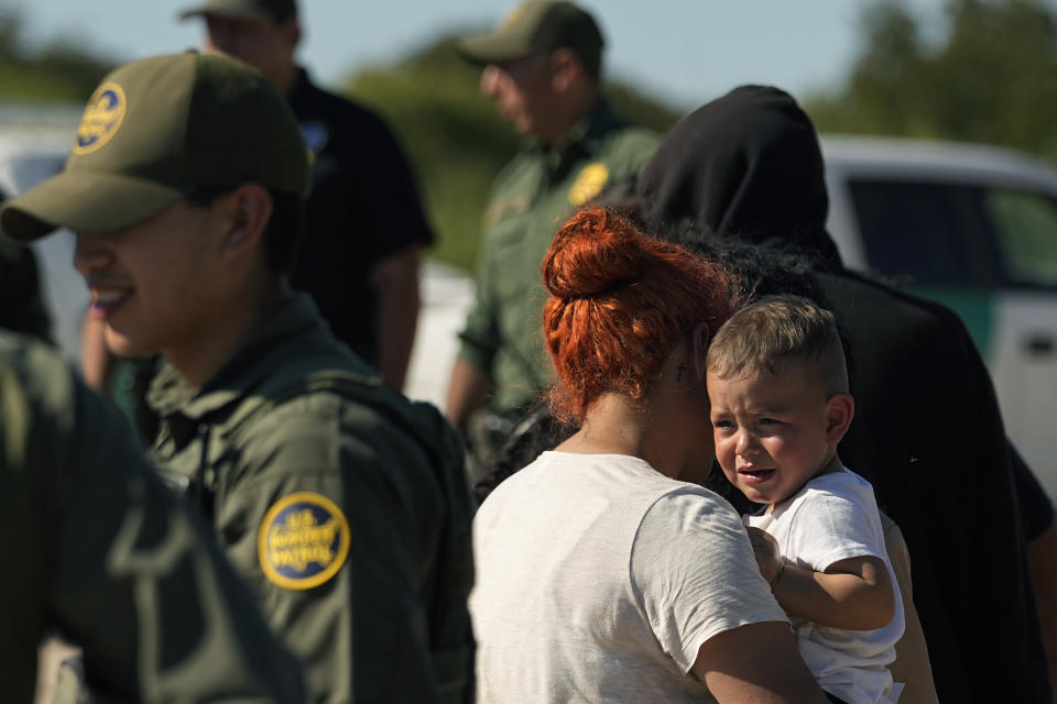 Migrants wait to be processed by the U.S. Customs and Border Patrol after they crossed the Rio Grande and entered the U.S. from Mexico, Thursday, Oct. 19, 2023, in Eagle Pass, Texas. Starting in March, Texas will give police even broader power to arrest migrants while also allowing local judges to order them out of the U.S. under a new law signed by Republican Gov. Greg Abbott. (AP Photo/Eric Gay)