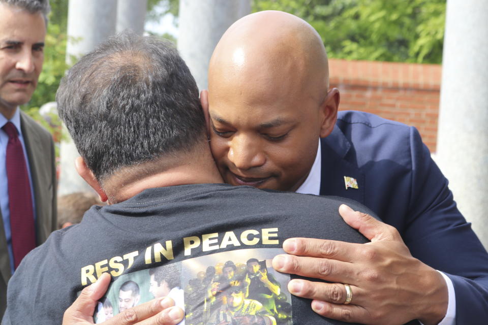 Maryland Gov. Wes Moore hugs Christian Segovia, Sr., at a wreath-laying ceremony at the Guardians of the First Amendment Memorial on Wednesday, June 28, 2023 in Annapolis, Md., five years after the attack on the Capital Gazette newsroom killed five people. Segovia's son, Christian Segovia, Jr., was one of three people who was killed in a shooting in Annapolis earlier this month. Maryland Rep. John Sarbanes is standing left. (AP Photo/Brian Witte)