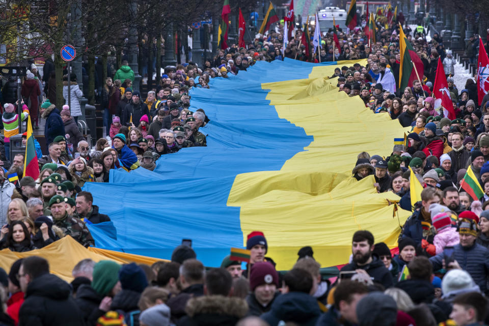 FILE - People carry a giant Ukrainian flag to protest against the Russian invasion of Ukraine during a celebration of Lithuania's independence in Vilnius, Lithuania, Saturday, March 11, 2023. Former Lithuanian President Dalia Grybauskaite has said that many Europeans still fail to understand the chasm in values between Russia and the West. She dismissed as "delusions" the idea that the two sides could find common ground through negotiations. (AP Photo/Mindaugas Kulbis, File)