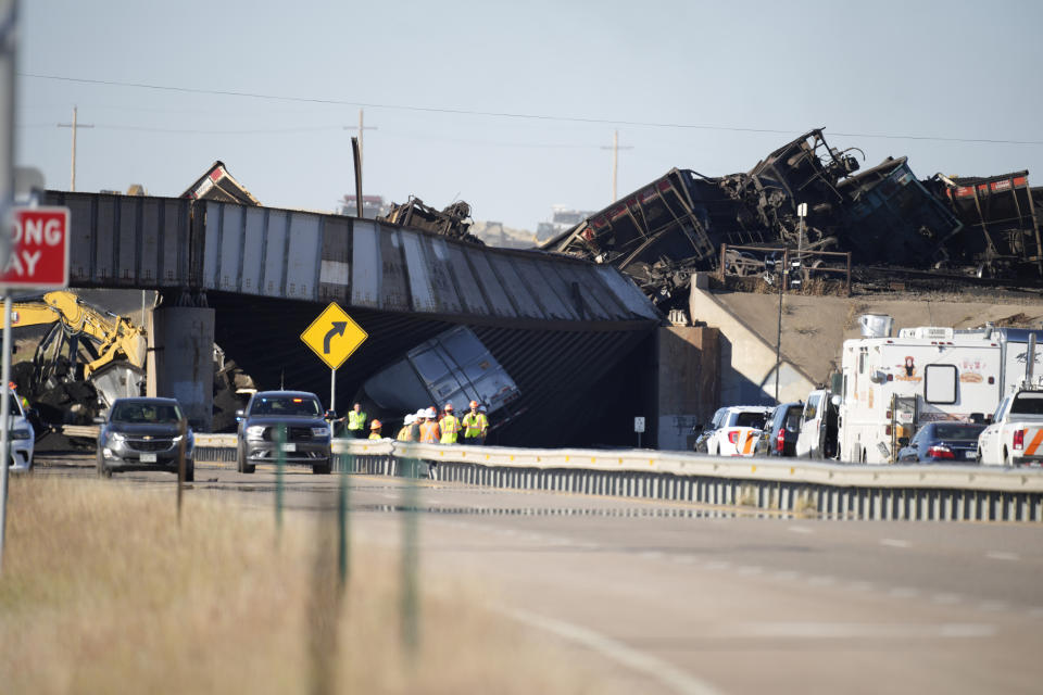 Workers toil to clear cars that derailed in an accident over Interstate 25 northbound, Monday, Oct. 16, 2023, north of Pueblo, Colo. (AP Photo/David Zalubowski)