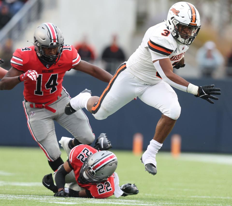 Massillon's Dorian Pringle evades the tackle from McKinley's Geno Kelly (22) and Ja'Diss Jackson during the 134th Massillon-McKinley high school football game at Tom Benson Hall of Fame Stadium in Canton, Saturday, October 21, 2023.