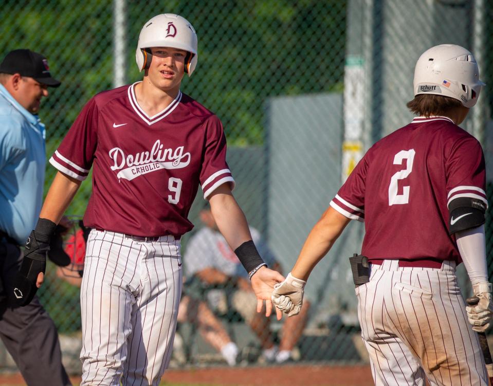 Trever Baumler (9) of Dowling Catholic celebrates after scoring a run against Des Moines East on June 23 in West Des Moines.