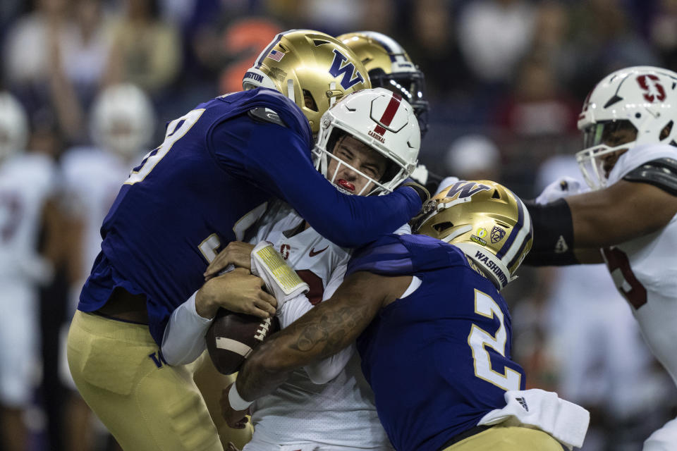 Washington's Zion Tupuola-Fetui, left, and Cam Bright, right, sack Stanford quarterback Tanner McKee during the first half of an NCAA college football game Saturday, Sept. 24, 2022, in Seattle. (AP Photo/Stephen Brashear)