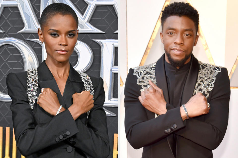 Letitia on the left wearing a pantsuit bedazzled on both shoulders similar to Chadwick's suit on the right. They are both doing the Wakandan salute