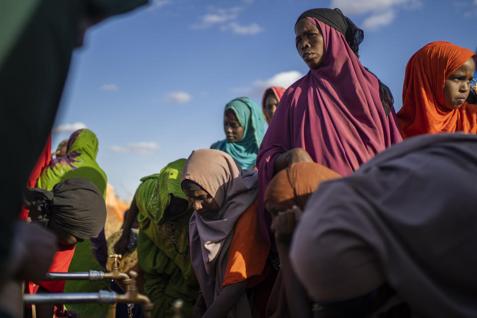 Varias mujeres buscan agua en unas canillas de un campamento para desplazados por una sequía en las afueras de Dollow (Somalia) el 21 de septiembre del 2022. (AP Photo/Jerome Delay).