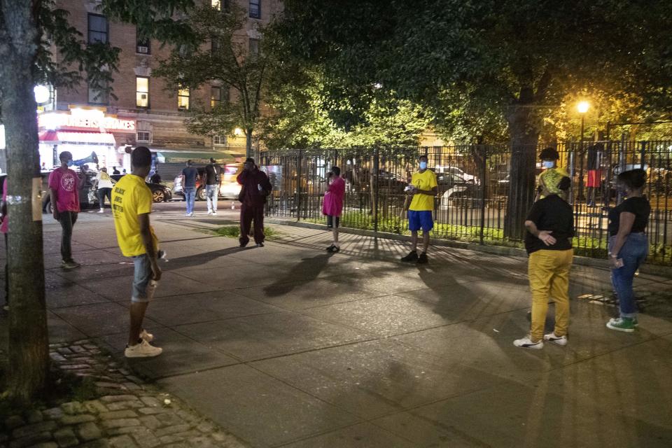 FILE - In this Saturday, July 18, 2020, file photo, Iesha Sekou, second from right, founder and CEO of Street Corner Resources, leads young men to "Occupy the Corner" to reach potential areas of conflict and gun violence, in the Harlem neighborhood of New York. A rise in gun violence in cities across the U.S. is testing the limits of anti-violence groups that have been calling for more government funding for decades. President Joe Biden acknowledged earlier this year that community anti-violence programs have been woefully underfunded and has proposed $5 billion in new aid for them. (AP Photo/Frank Franklin II, File)