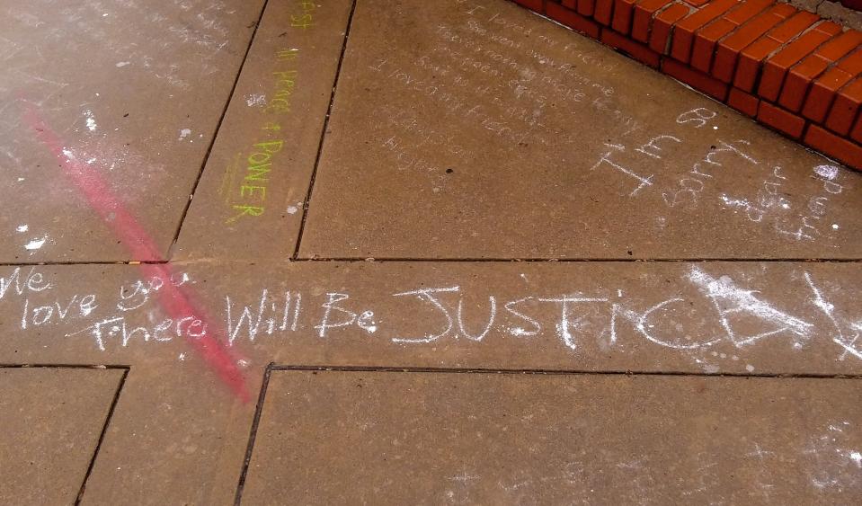 Sidewalks around Okie Baking Co., headquartered in Main Street's Cookie Cottage, were were adorned with flowers and chalk messages on Monday.