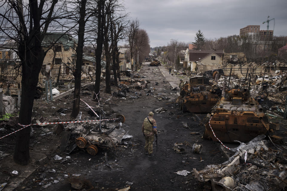 A Ukrainian serviceman walks amid destroyed Russian tanks in Bucha, on the outskirts of Kyiv, Ukraine, Wednesday, April 6, 2022. (AP Photo/Felipe Dana)