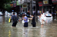 People walk through a flooded street as Typhoon Hato hits Dongguan, Guangdong province, China August 23, 2017. REUTERS/Stringer