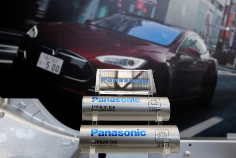 Panasonic Corp's lithium-ion batteries, which are part of Tesla Motor Inc's Model S and Model X battery packs, are displayed in front of a poster of a Tesla Model S during a news conference at the Panasonic Center in Tokyo, Japan, November 19, 2013. REUTERS/Yuya Shino/Files