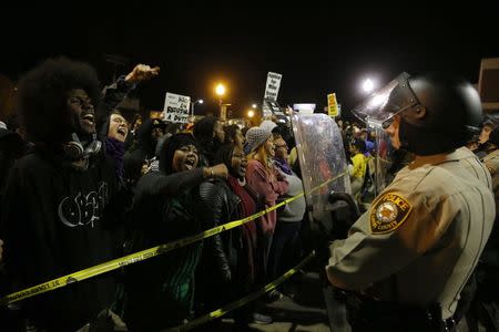 Protesters square off against police during a rally for Michael Brown outside the police department in Ferguson, Missouri, October 11, 2014. REUTERS/Jim Young