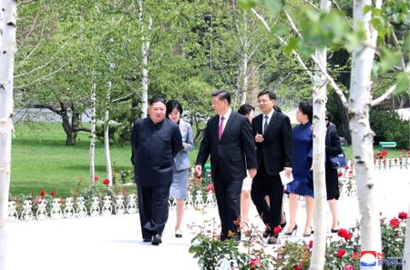 North Korean leader Kim Jong Un walks with Chinese President Xi Jinping during Xi's visit in Pyongyang