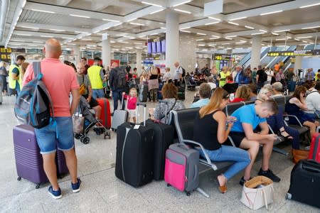 Passengers are seen at Thomas Cook check-in points at Mallorca Airport after the world's oldest travel firm collapsed, in Palma de Mallorca