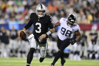 Las Vegas Raiders quarterback Jarrett Stidham (3) scrambles for a touchdown with Jacksonville Jaguars defensive end Jeremiah Ledbetter (98) in pursuit during the first half of the NFL football exhibition Hall of Fame Game, Thursday, Aug. 4, 2022, in Canton, Ohio. (AP Photo/David Dermer)