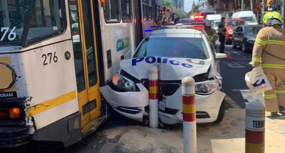 A smashed Victoria Police car sits next to a tram after a crash in Melbourne's CBD.