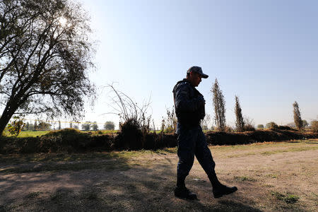 A federal police officer keeps watch at the site where a fuel pipeline, ruptured by suspected oil thieves, exploded in the municipality of Tlahuelilpan, state of Hidalgo, Mexico January 22, 2019. Picture taken January 22, 2019. REUTERS/Mohammed Salem