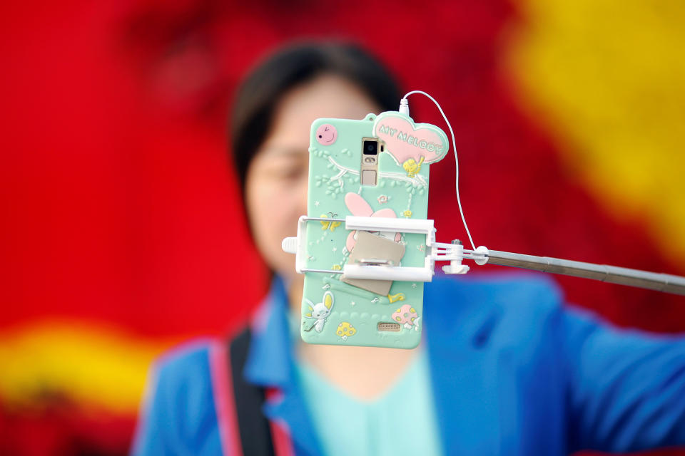 <p>A woman takes pictures of herself as people gather in Tiananmen Square to celebrate National Day marking the 67th anniversary of the founding of the People’s Republic of China, in Beijing October 1, 2016. (REUTERS/Damir Sagolj) </p>