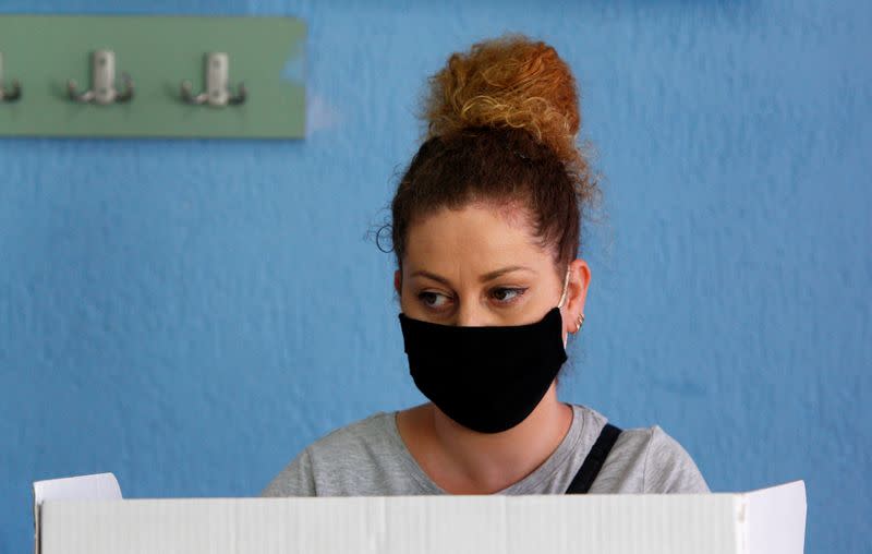 A woman wearing a face mask is seen at a polling station during the general election, in Strumica