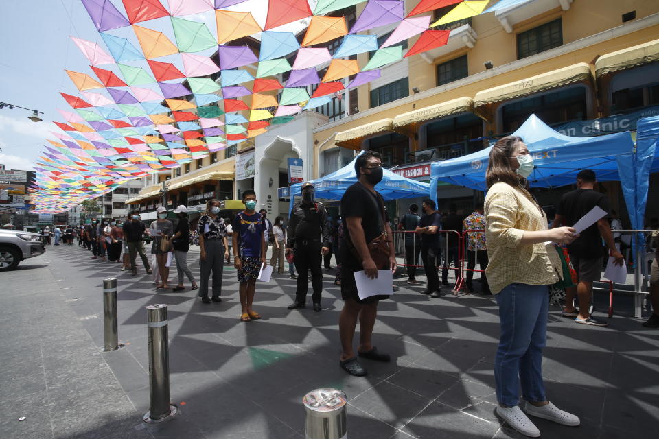 People wait in line for COVID-19 swab tests in Khaosan Road in Bangkok, Thailand Wednesday, April 14, 2021. Thailand recorded more than 1,000 COVID-19 infections on Wednesday, setting a daily record and adding pressure on the government to do more to control the country's spiking transmission rates. (AP Photo/Somchai Chanjirakitti)