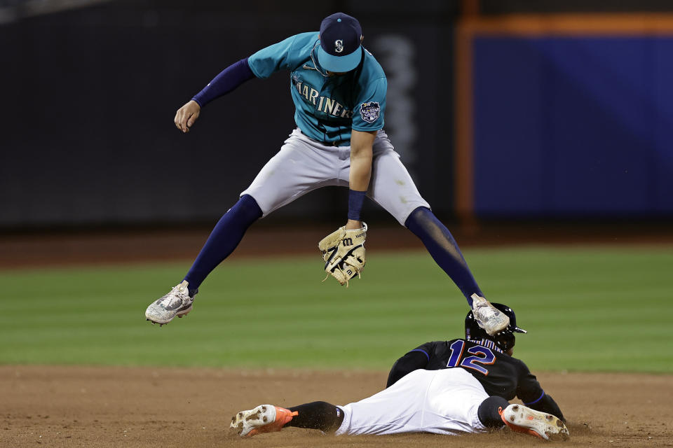 New York Mets' Francisco Lindor (12) steals second base under Seattle Mariners second baseman Josh Rojas, top, during the eighth inning of a baseball game Friday, Sept. 1, 2023, in New York. (AP Photo/Adam Hunger)