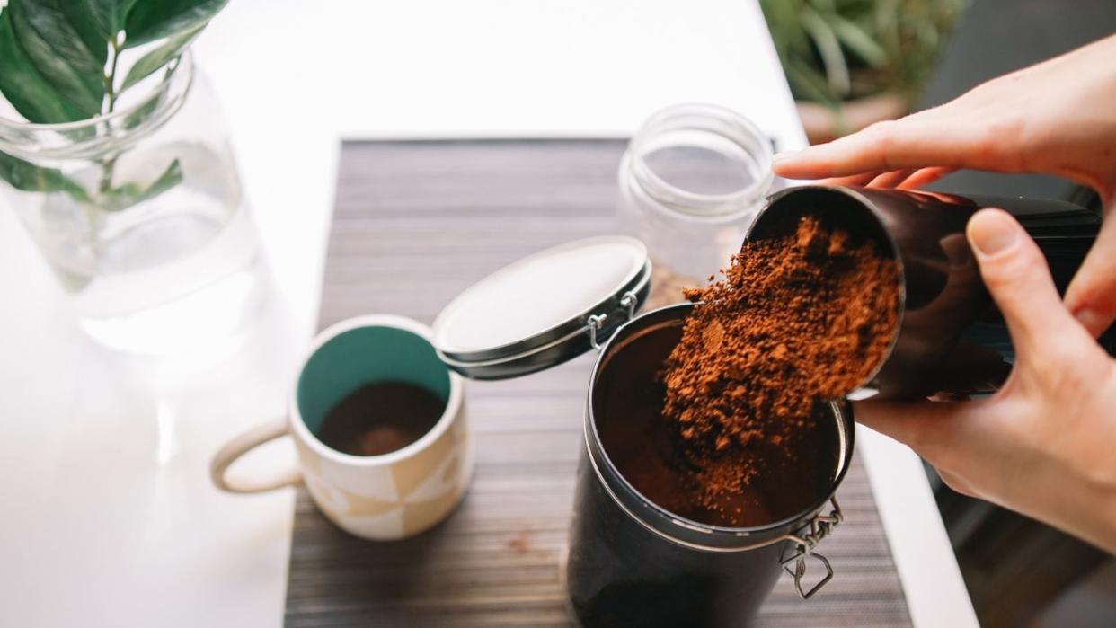  An example of how to store coffee grounds - pouring coffee into a sealable jar 