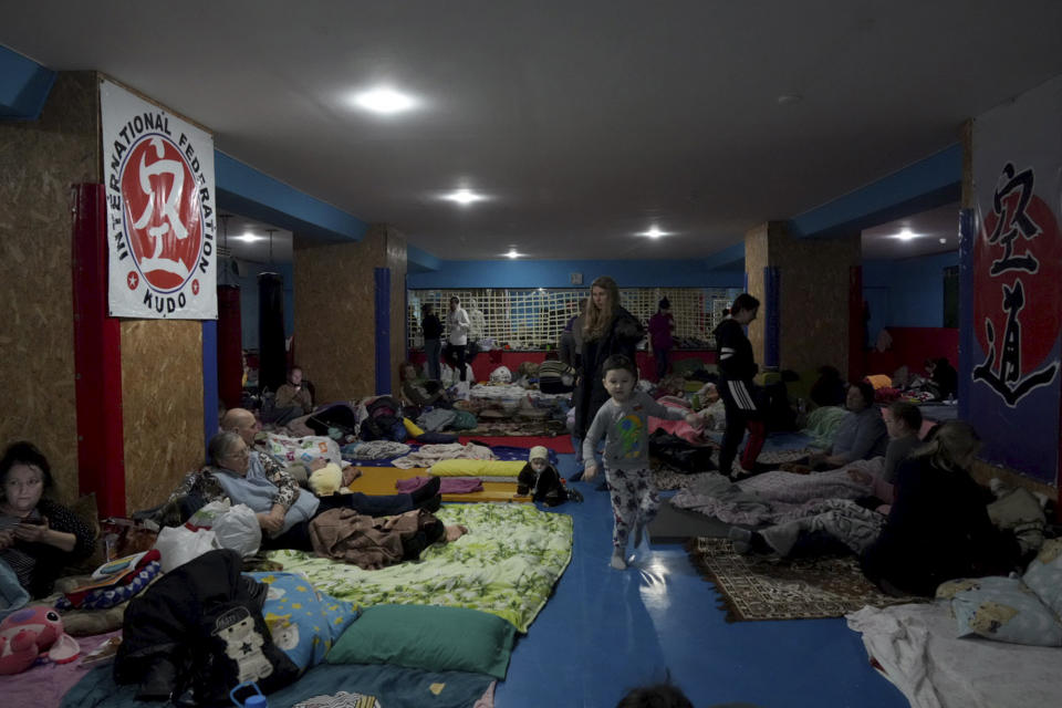 People take shelter inside a building in Mariupol, Ukraine, Sunday, Feb. 27, 2022. Street fighting broke out in Ukraine's second-largest city and Russian troops squeezed strategic ports in the country's south as the prospect of peace talks remains uncertain. (AP Photo/Evgeniy Maloletka)