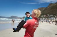 A coach carried nine-year-old JJ Booysens to the beach at a recent adaptive surfing event