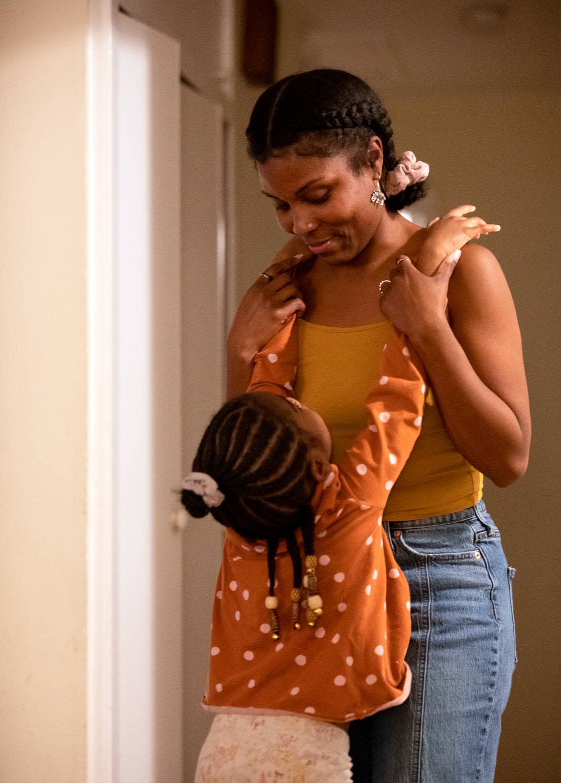 Sheba Everett hugs her daughter, Hannah Edgerton, 5, at their home in Durham, N.C. on Wednesday, Oct. 26, 2022. After renting the house where she lives with her five daughters for over two years, Everett received a notice to vacate by May 31, 2023. The Eno River Association, which owns this home and six others nearby, plans to transfer the property to the state.