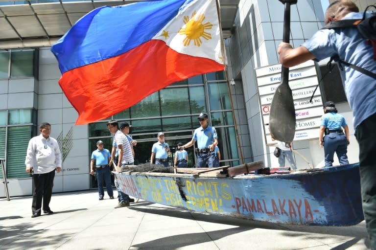 Fishermen and activists carry a wooden fishing boat during a protest outside the Chinese consulate in Manila ahead of a UN tribunal ruling on the legality of China's claims to the South China Sea