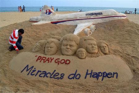 Indian sand artist Sudarshan Patnaik applies the final touches to a sand art sculpture he created wishing for the well being of the passengers of Malaysian Airlines flight MH370, on a beach in Puri, in Odisha, March 9, 2014. REUTERS/Stringer