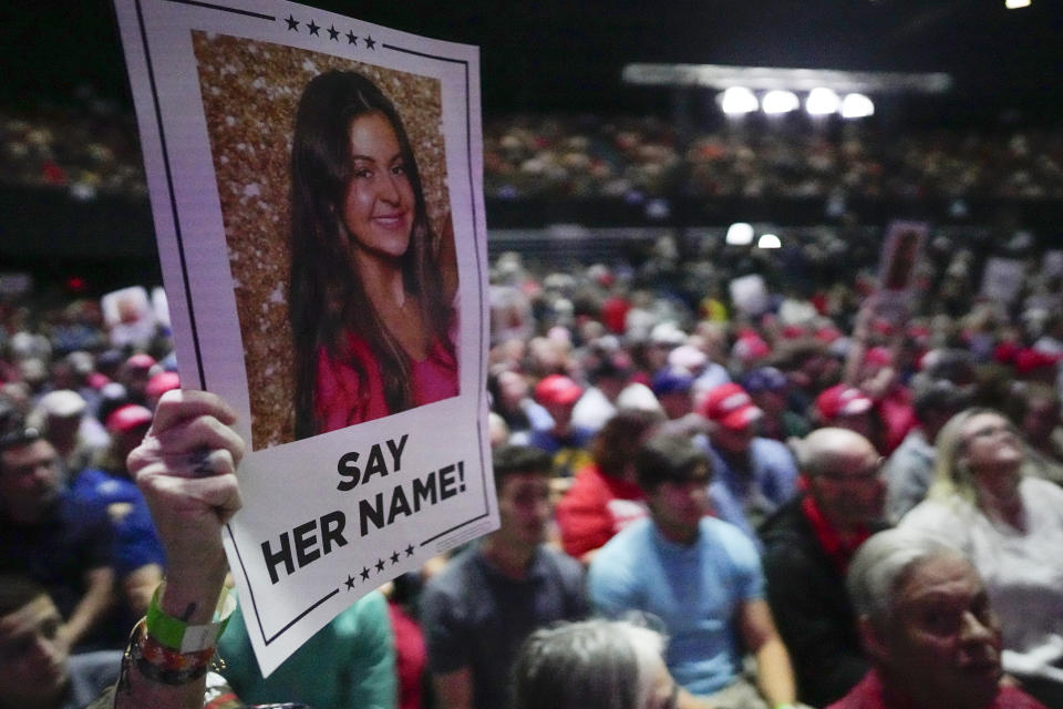 A supporter holds a oster with a photo of Laken Riley before Republican presidential candidate former President Donald Trump speaks at a campaign rally Saturday, March 9, 2024, in Rome Ga. (AP Photo/Mike Stewart)