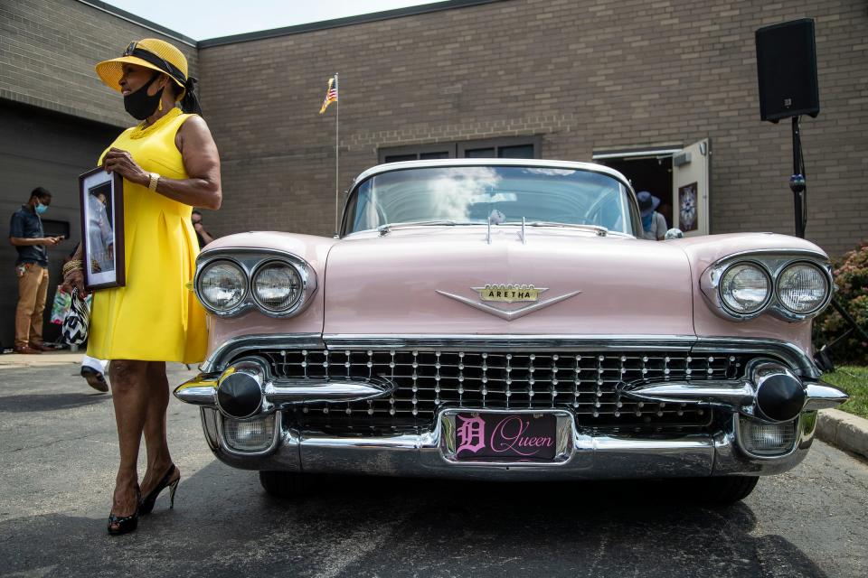 Beverly Bradley, Aretha Franklin's close friend, poses for a photo next to a pink Cadillac during the Aretha Franklin Memorial Highway dedication ceremony in Detroit on Aug. 24, 2020. Scores of pink Cadillacs were on display for the Queen of Soul's funeral in 2018 to celebrate her song "Freeway of Love." Cadillacs also figure prominently in some key car songs.