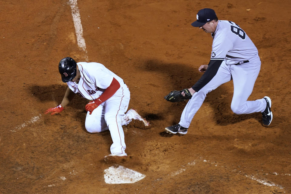 Boston Red Sox's Rafael Devers slides safely into home on a wild pitch by New York Yankees reliever Brooks Kriske (82), who cannot reach him with a tag in the 10th inning of a baseball game at Fenway Park, Thursday, July 22, 2021, in Boston. The Red Sox won 5-4. (AP Photo/Elise Amendola)