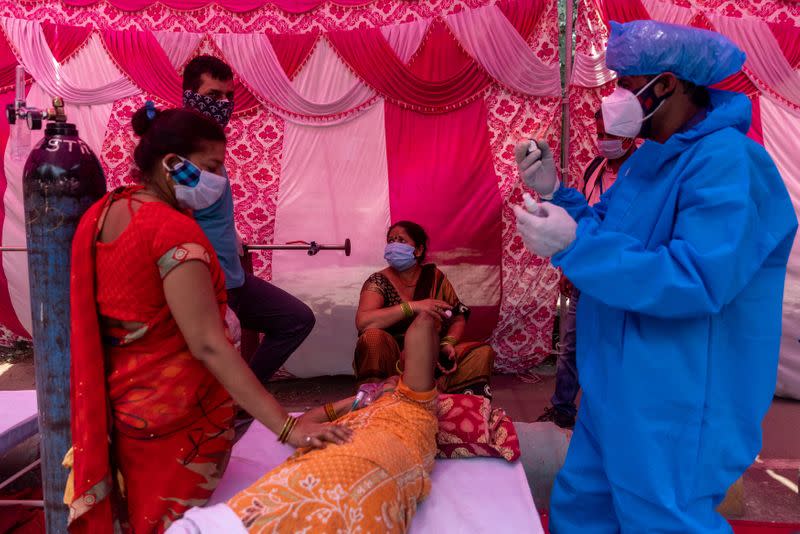 A woman surrounded by her relatives receives oxygen support for free at a Gurudwara in Ghaziabad