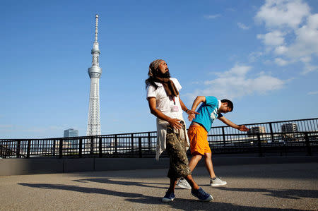 Tokuchika Nishi (L), a 38-year-old homeless man and a member of Newcomer "H" Sokerissa! - a group of current and former homeless dancers, performs with an other member in front of Tokyo Sky Tree, the world's tallest broadcasting tower at 634 metres, in Tokyo, Japan, September 8, 2017. REUTERS/Toru Hanai