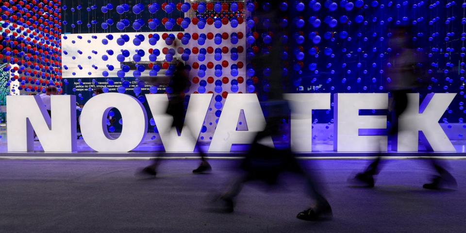 People walk past a sign reading 'Novatek' at the St. Petersburg International Economic Forum in Russia, June 2, 2021