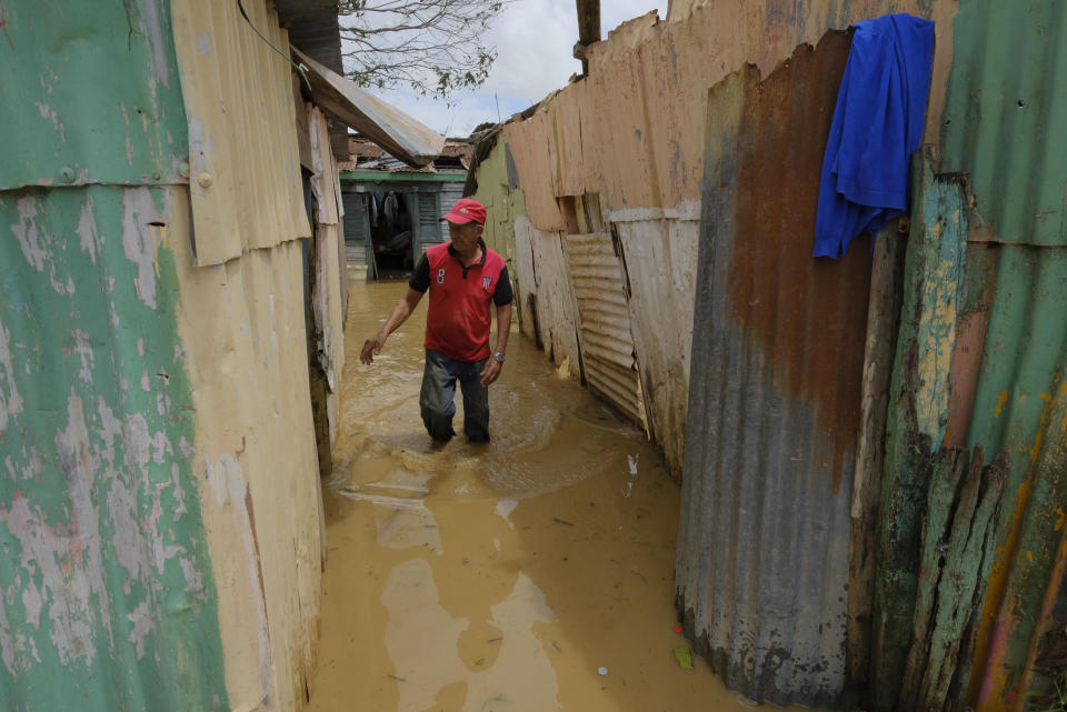 Nicasio Gil walks through the stagnant water left by the swollen Duey river, caused by Hurricane Fiona in the Los Sotos neighborhood in Higüey, Dominican Republic, Tuesday, Sept. 20, 2022.(AP Photo/Ricardo Hernandez)