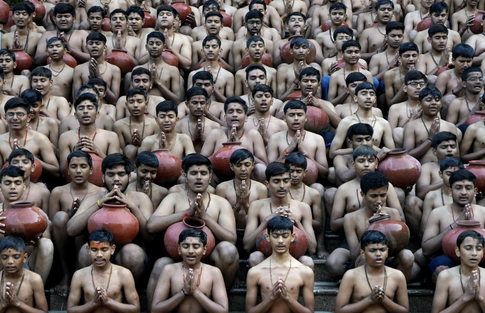 Indian students of the Swaminarayan Gurukul pray after demonstrating a ritualistic bath called Magh Snan for the media in Ahmedabad, India, Wednesday, Jan. 24, 2024. Devotees believe that a purification bath taken during the auspicious Hindu calendar month of Magh, which begins Thursday, will absolve them of their sins. (AP Photo/Ajit Solanki)