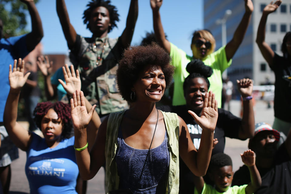 <p>Demonstrators raise their hands and chant “hands up, don’t shoot” during a protest over the killing of Michael Brown on August 12, 2014 in Clayton, Missouri. Some reports state that Brown hand his hands in the air when he was shot and killed by a police officer on Saturday in suburban Ferguson, Missouri. Two days of unrest including rioting and looting have followed the shooting in Ferguson. Browns parents have publicly asked for order. (Scott Olson/Getty Images) </p>