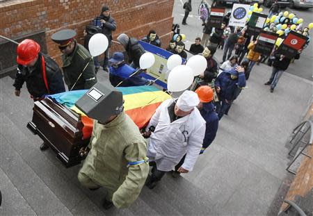 People dressed in outfits of various popular professions in Ukraine carry a coffin symbolising Ukraine's Euro-association and to the EU Delegation building in Ukraine during a symbolic funeral procession and an anti-Europe rally in Kiev November 28, 2013. REUTERS/Gleb Garanich