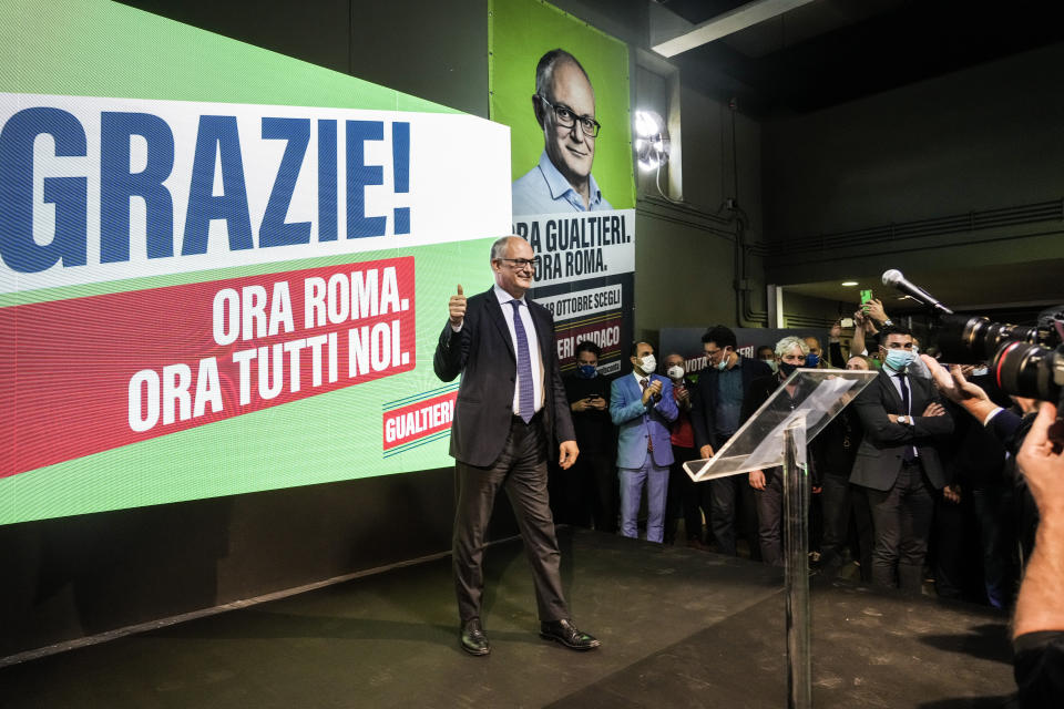 Center-left mayoral candidate Roberto Gualtieri stands in front of his electoral posters at his party's headquarters in Rome, Monday, Oct. 18, 2021. Gualtieri is claiming victory after first projections indicated he headed to a resounding victory. The top vote-getters in the first round of balloting two weeks earlier, Enrico Michetti, a novice politician backed by a far-right leader, and Roberto Gualtieri, a Democrat and former finance minister, competed in the runoff Sunday and Monday. Italian writing in the background reads 'Thank you! Now Rome! Now all of us. (AP Photo/Gregorio Borgia)