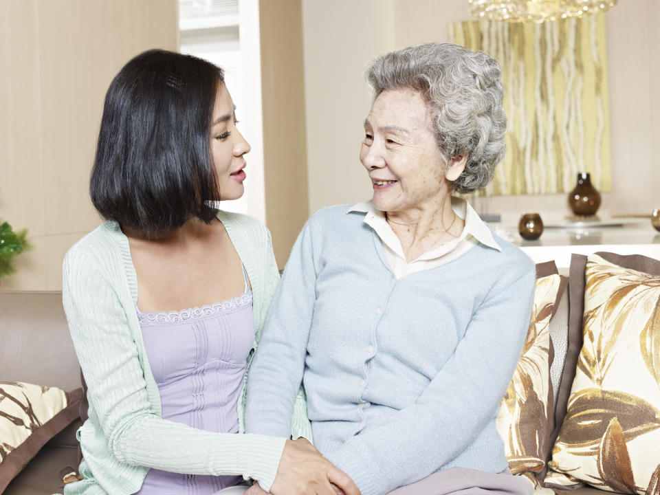 senior asian mother chatting with adult daughter at home.