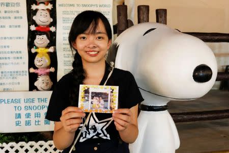 Apple Siu poses with her childhood photo around the same spot where it was taken in Hong Kong, China June 14, 2017. REUTERS/Tyrone Siu