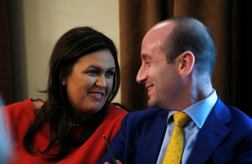 White House press secretary Sarah Huckabee Sanders laughs with White House senior adviser Stephen Miller during a cabinet meeting in July. (Leah Millis / Reuters)