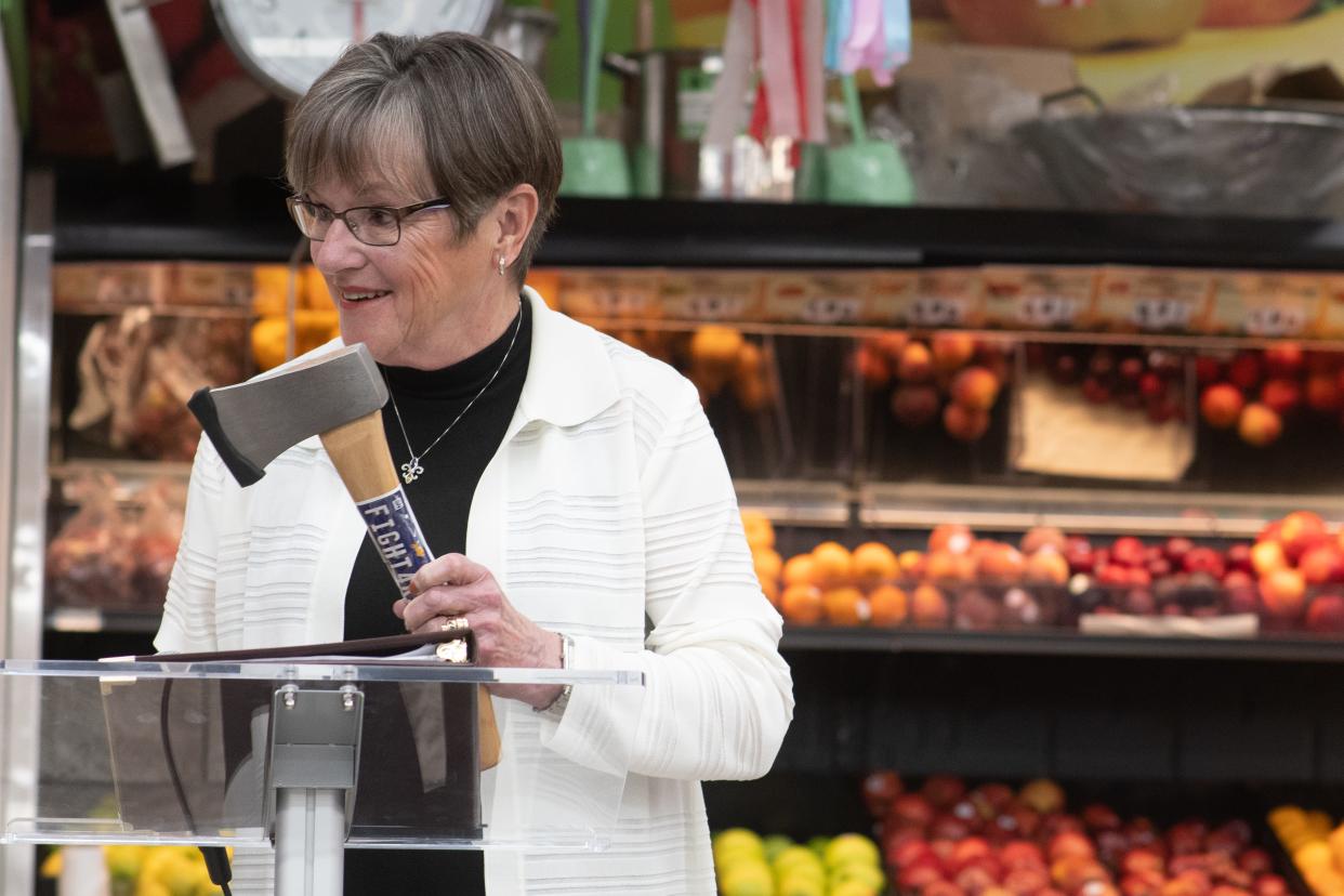 Gov. Laura Kelly holds up an axe before speaking on the food sales tax bill she signed June 13 at Mi Pueblito Meat Market, 621 S.E. Swygart St., in Topeka.