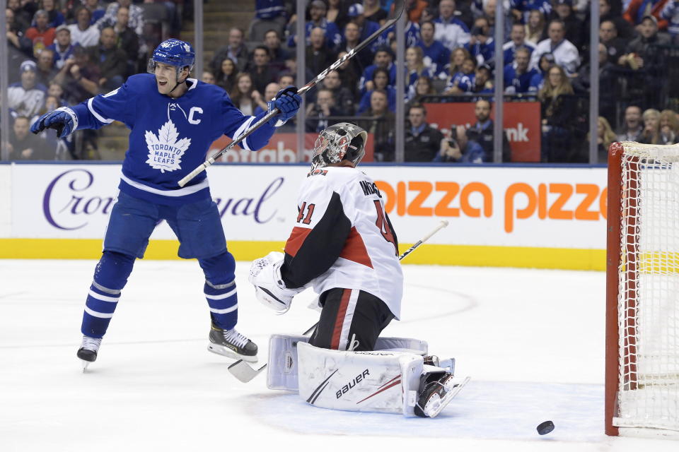 Toronto Maple Leafs centre John Tavares (91) celebrates teammate Mitch Marner's game winning goal against Ottawa Senators goaltender Craig Anderson (41) during overtime NHL hockey action in Toronto, Saturday, Feb. 1, 2020. (Nathan Denette/The Canadian Press via AP)